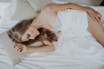 Obraz na płótnie Canvas blonde girl asleep in the bedroom dreams holiday morning