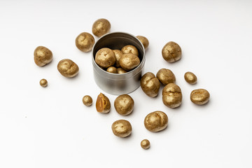 Gray metal bowl full of chocolate pralines. Sweet truffles with cinamon, cardamom and clove on a white isolated background.