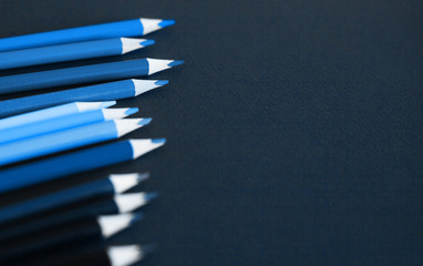 Colored pencils against dark blue background. Close up and selective focus.