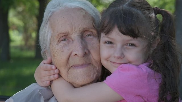 Happy face of grandmother. Happy little girl hugs her grandmother. Portrait of a grandmother with her granddaughter.
