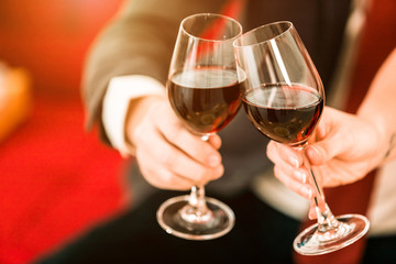 Close up of a business suit of man and girl two people holding glasses of Clinking Champagne on xmas and the new years eve party.