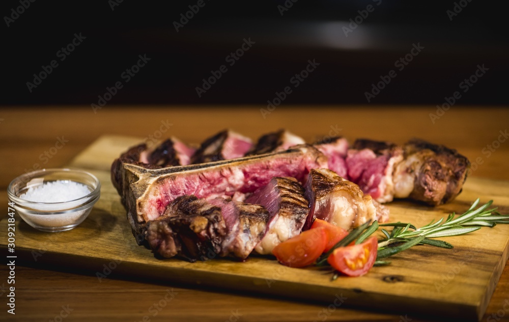 Poster Delicious tasty dinner with red meat and vegetables on a wooden surface