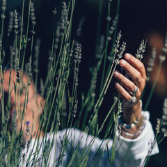 Abundance Feeling.  Mindful Middle-aged Woman Touching Lavender Flowers, Feeling Thankful