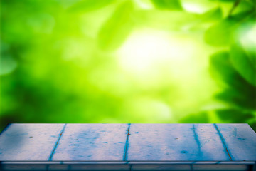 Empty blue rustic wooden plank against to bright green plants environment for putting your products