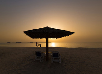 UAE, landscape sea, sunset, beach umbrella and sunbeds