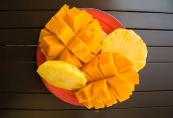 UAE. Fruits mango and pineapple, brawn wooden table