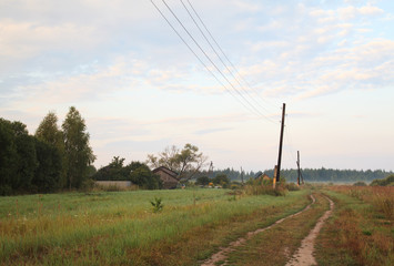 Early foggy morning sunrise in the Russian countryside, view of the road