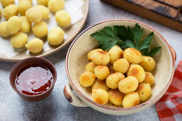 Bowl of roasted italian potato gnocchi with uncooked gnocchi in the background, horizontal shot