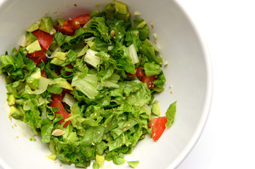 Vegetable salad with avocado, leaves, tomato, sesame seeds, garlic, lemon juice.
