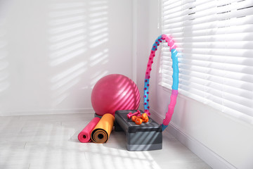 Different sports equipment near window in gym