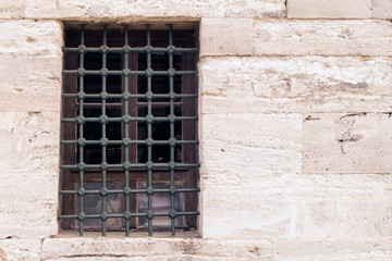 old stone wall with Windows in metal bars