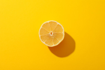 Half of lemon on yellow background, space for text