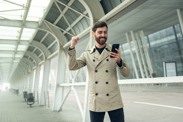Fototapeta premium Good Business News. Businessman using smart phone.