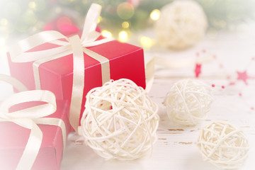Christmas background, with red gift box and wicker white ball, on bokeh background.