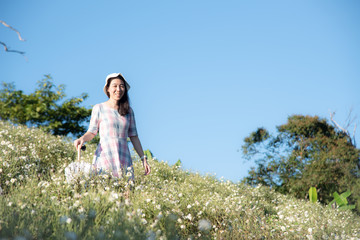 The woman in a flowers field and blue sky background, Copy space