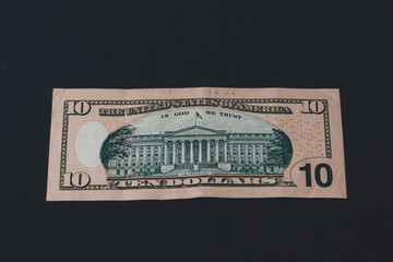 Ten Americandollars are on the back of a black background.