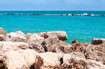 Massive stones rocks lying on the beach as a border between pebble beach Spiaggia del Frate and...