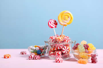 various candy and sweets on the table on a colored background. 