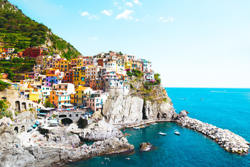 Fototapeta na wymiar A beautiful landscape of the Manarola village of Cinque Terre located in northern Italy and the blue sea with yachts and boats