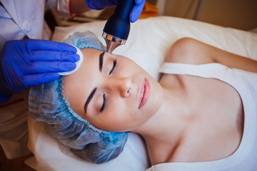 Cosmetology doctor makes woman treatments facial massage