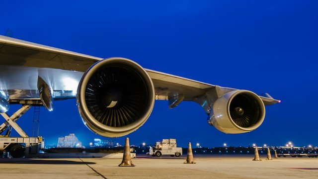Zoom out time lapse cargo aircraft loading at twilight sky	