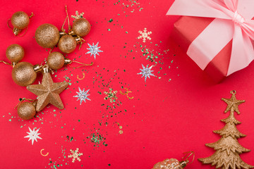 Beautiful festive red background with sparkles and Christmas golden toys. Holiday Content. New year