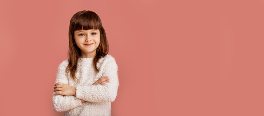 Obraz premium Professional confident children concept. Child girl with pretty smiling face over pink background, lifestyle people. Trendy clever modern kid. 
