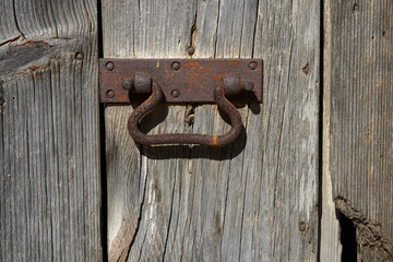 An old metal handle on a wooden door