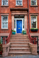 A colorful blue door on a historic brownstone building in Manhattan, NYC