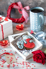 Cookies or gingerbread cookies in a gift box with a red ribbon on a wooden table. Valentine's Day.