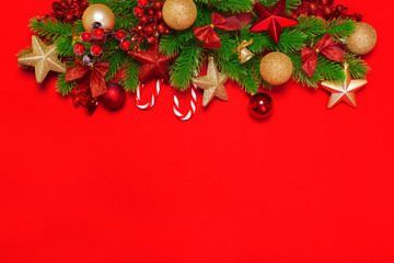 Christmas red background with herringbone and decor. Gold and red jewelry. Top view with space for copy.