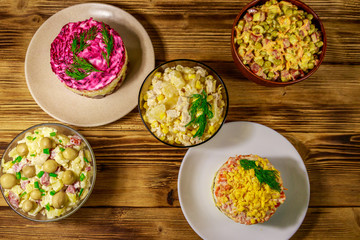Set of festive mayonnaise salads on wooden table. Top view