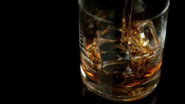 Super slow motion of pouring whiskey into glass. Filmed on high speed cinema camera, 1000fps