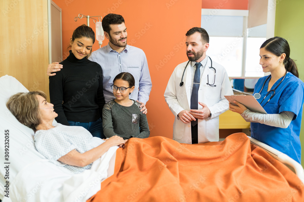 Wall mural doctors explaining family with senior patient at hospital