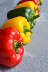 Row of multi-colored fresh bell peppers. Green, red and yellow vegetables. Organic healthy food concept