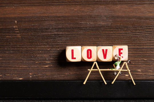 painter figure and wooden blocks with the word "LOVE" on wooden background