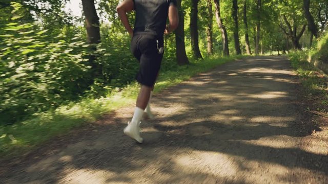 Muscular afro man running in morning through green forest