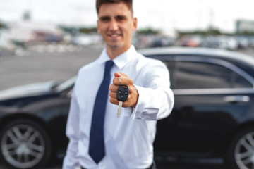Fototapeta na wymiar Young man sales Manager shows you car keys