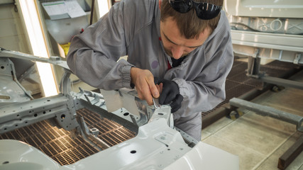 Employee car body painting shop eliminates a small metal defect