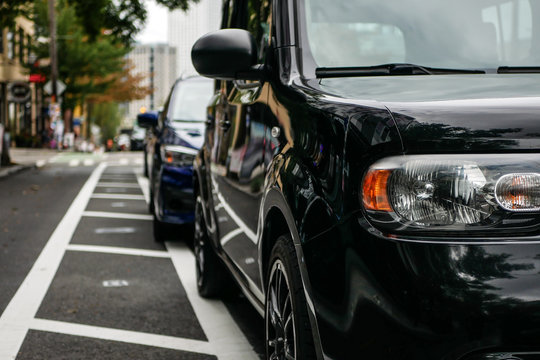 Close up of row of cars parked neatly on the street. Blur background