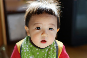 朝、寝癖頭でぼーっとしている赤ちゃん