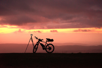 Naklejka premium With e-bike and camera equipment for sunset on a mountain