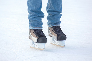 feet on the skates of a person rolling on the ice rink. Hobbies and sports. Vacations and winter activities.