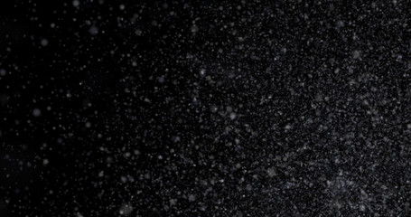 Natural white winter snowfall on a black background