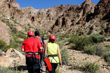 A team of rock climbers walking to a cliff and wearing safety harness and climbing equipment outdoor. Mendoza, Argentina.