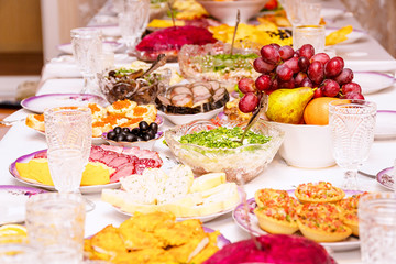 Served table. Snacks, fruits, sandwiches, salads, caviar and slicing on the holiday table. Selective focus