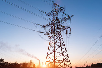 High-voltage power lines at sunset or sunrise. High voltage electric transmission tower