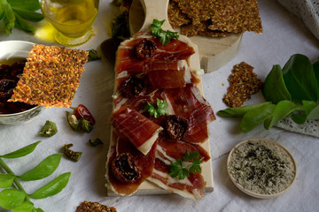  A cutting board  with  Traditional  tapas    with  spanish cured meat, sun dried tomato , parsley...