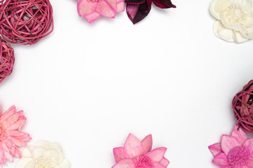 Fototapeta na wymiar weiße rosa Blüten und Holzgeflechtkugeln am Rand mit Freiraum für Text in der Mitte