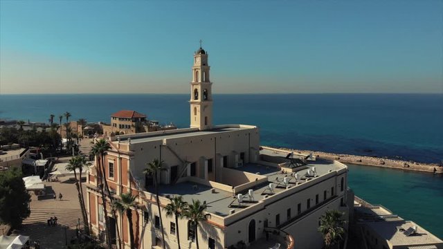 The old temple of Peter on the shores of the Mediterranean Sea. Israel, Tel Aviv, Jaffa, Middle East. Old city top view. Aerial photography. Orthodox church, tower and cross, bell.